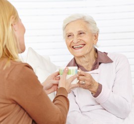 Familie mit Seniorin trinkt Kaffee