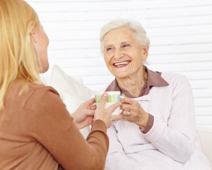 Familie mit Seniorin trinkt Kaffee